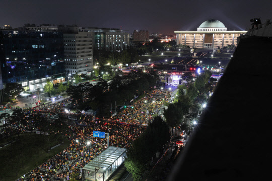 지난 19일 오후 서울 여의도 국회 앞에서 열린 '사법적폐청산을 위한 제10차 검찰개혁 촛불문화제'에서 참가자들이 촛불을 들고 공수처 설치, 검찰개혁 법안 통과 등을 촉구하는 파도타기를 하고 있다. 연합뉴스